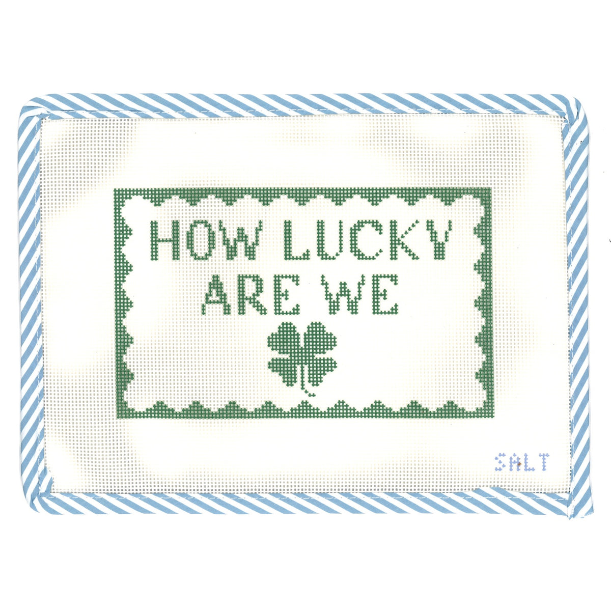 "How Lucky Are We" needlepoint canvas in green with a four-leaf clover motif and blue striped edge trim